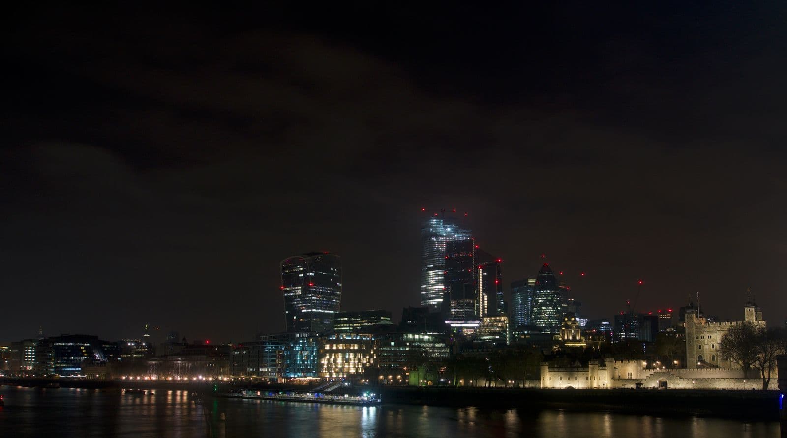 London skyline at night over the River Thames, with the Tower of London