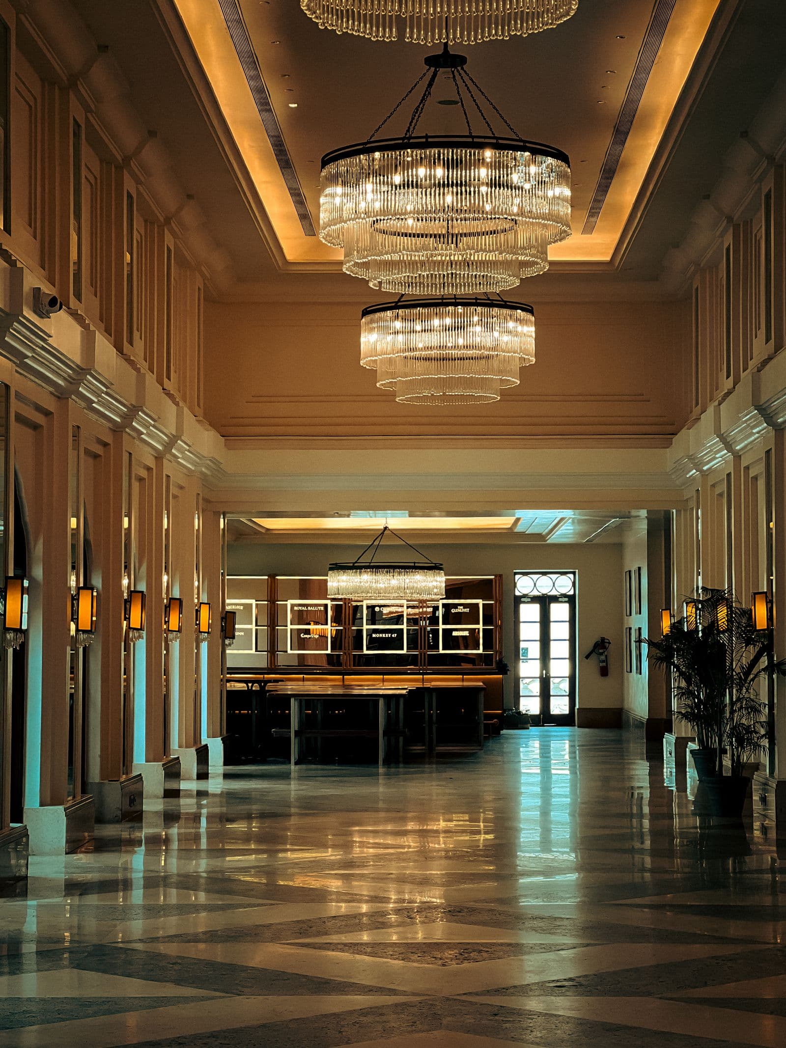 Grand hotel lobby with tiered crystal chandeliers and marble floor