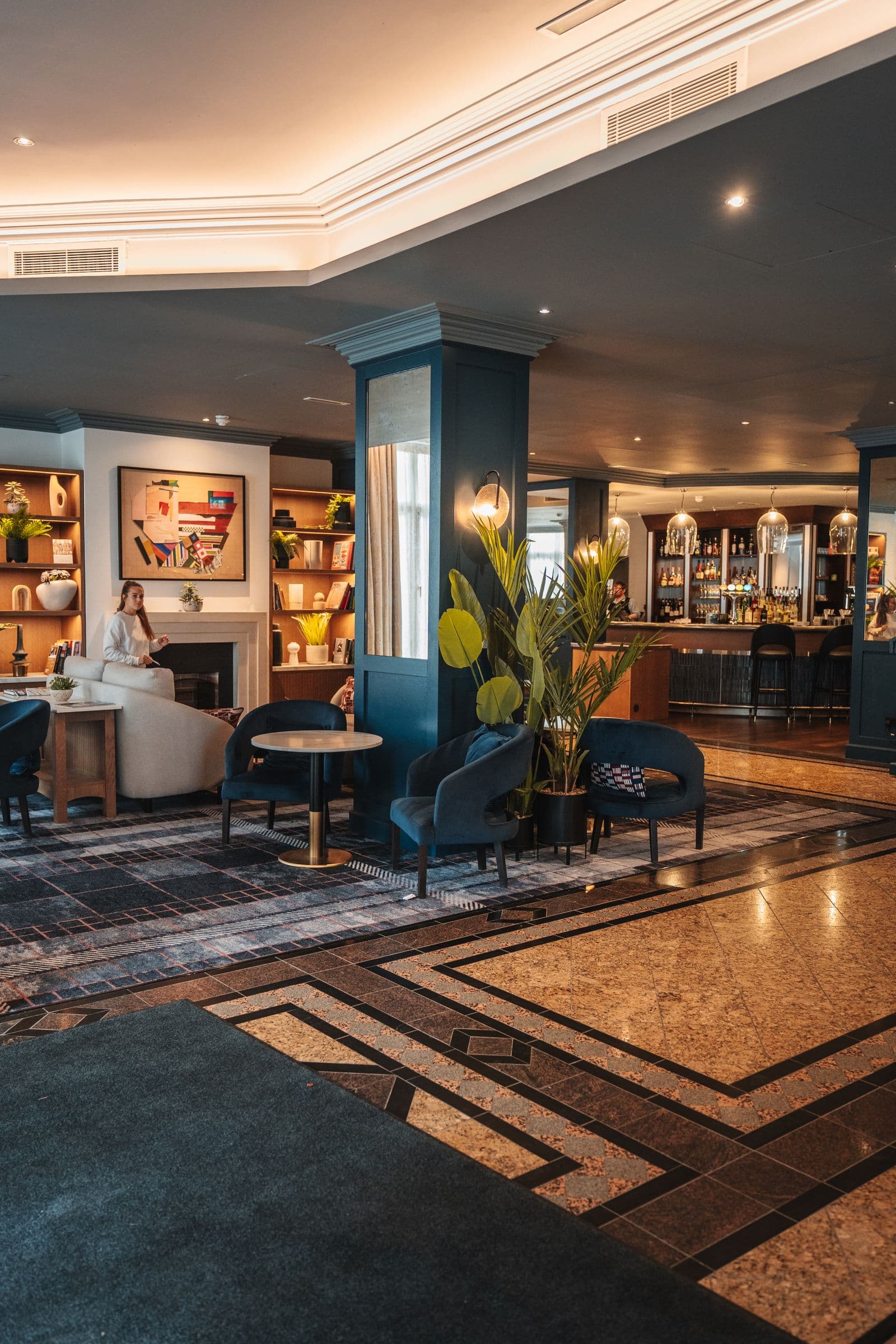 Elegant hotel bar lounge with a backlit shelf of spirits